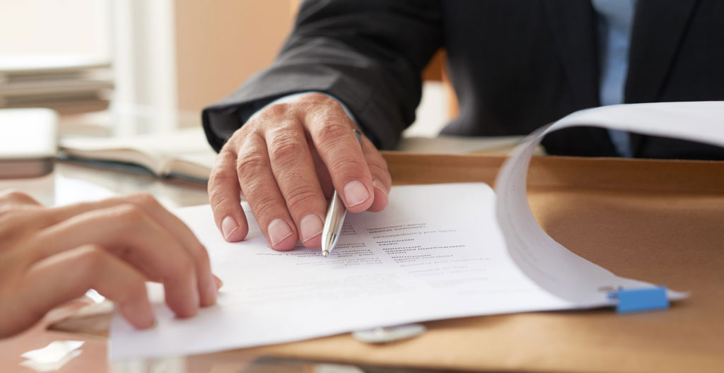 Signature d'un contrat d'alternance sur un bureau avec documents officiels et tampon d'entreprise